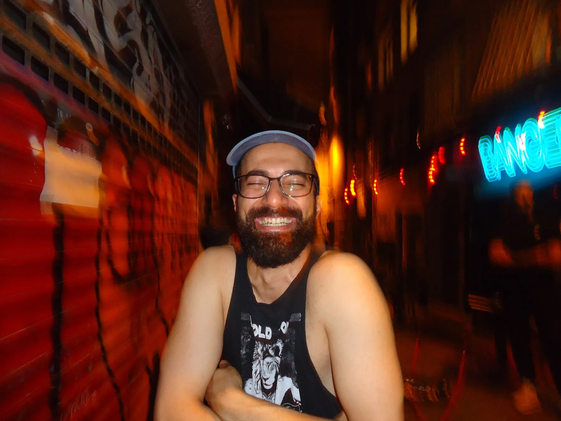 Smiling man in a cap on a street at night