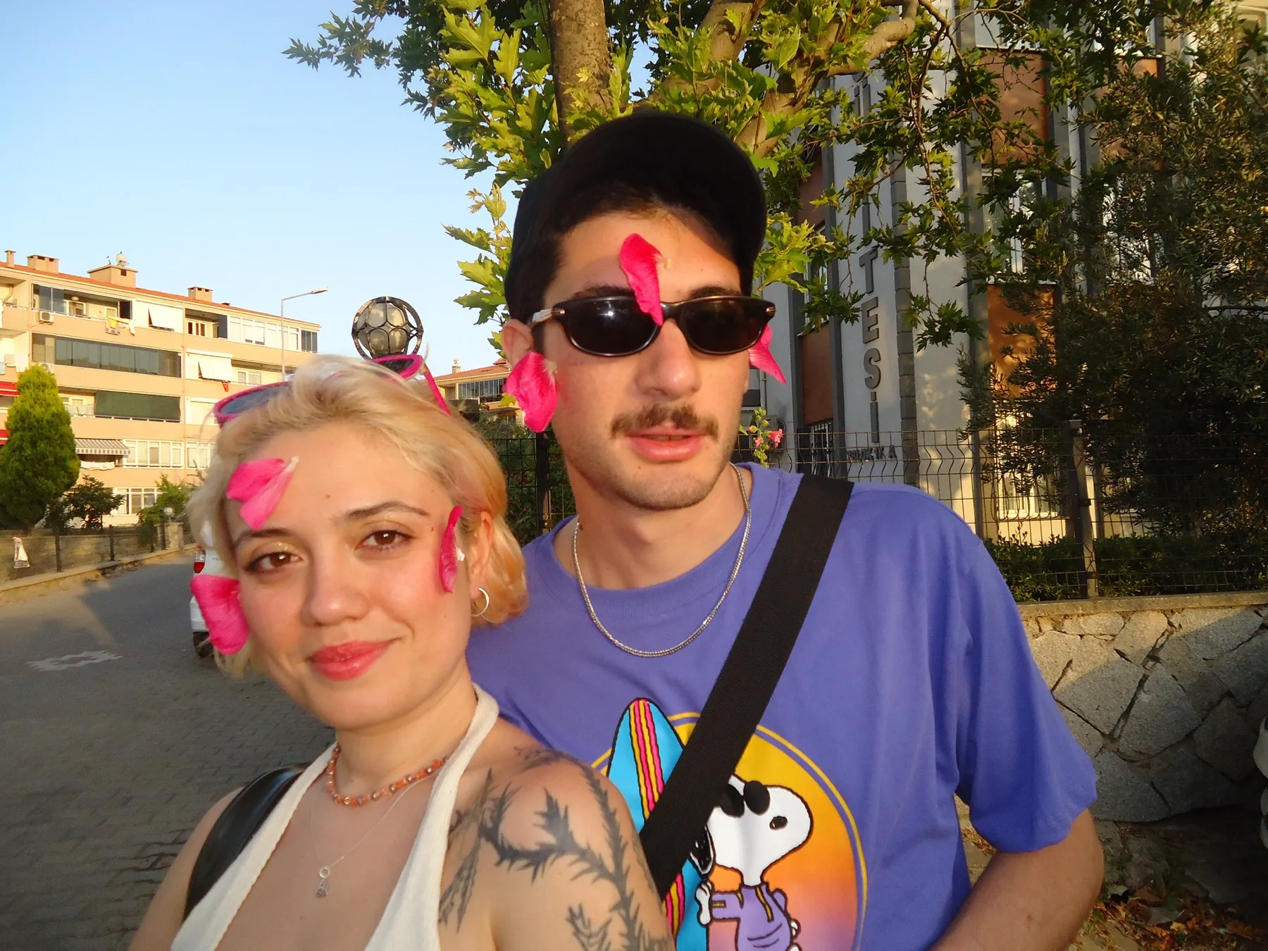 Two friends with pink paper hearts on their faces