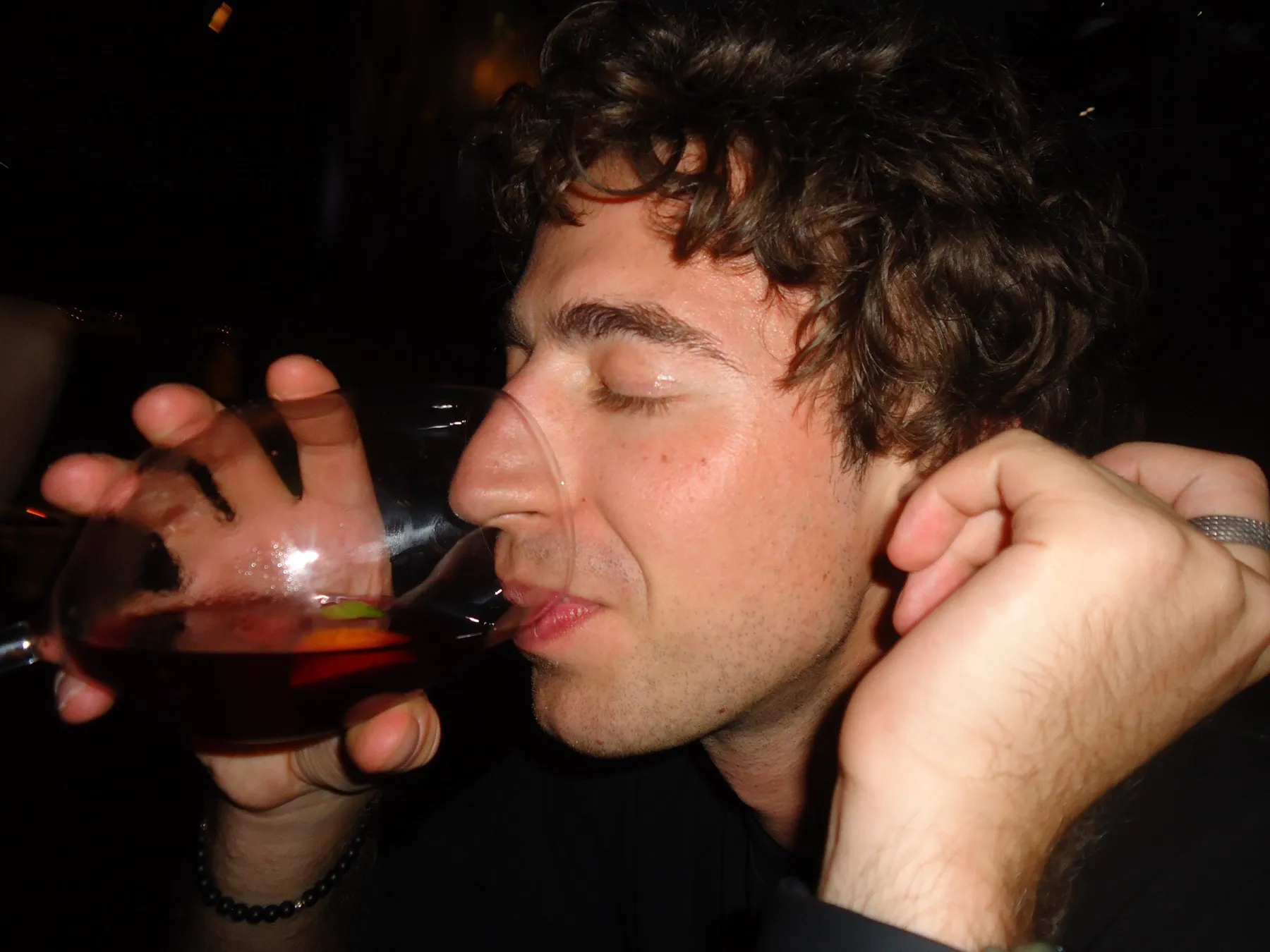 Man drinking red wine with his eyes closed
