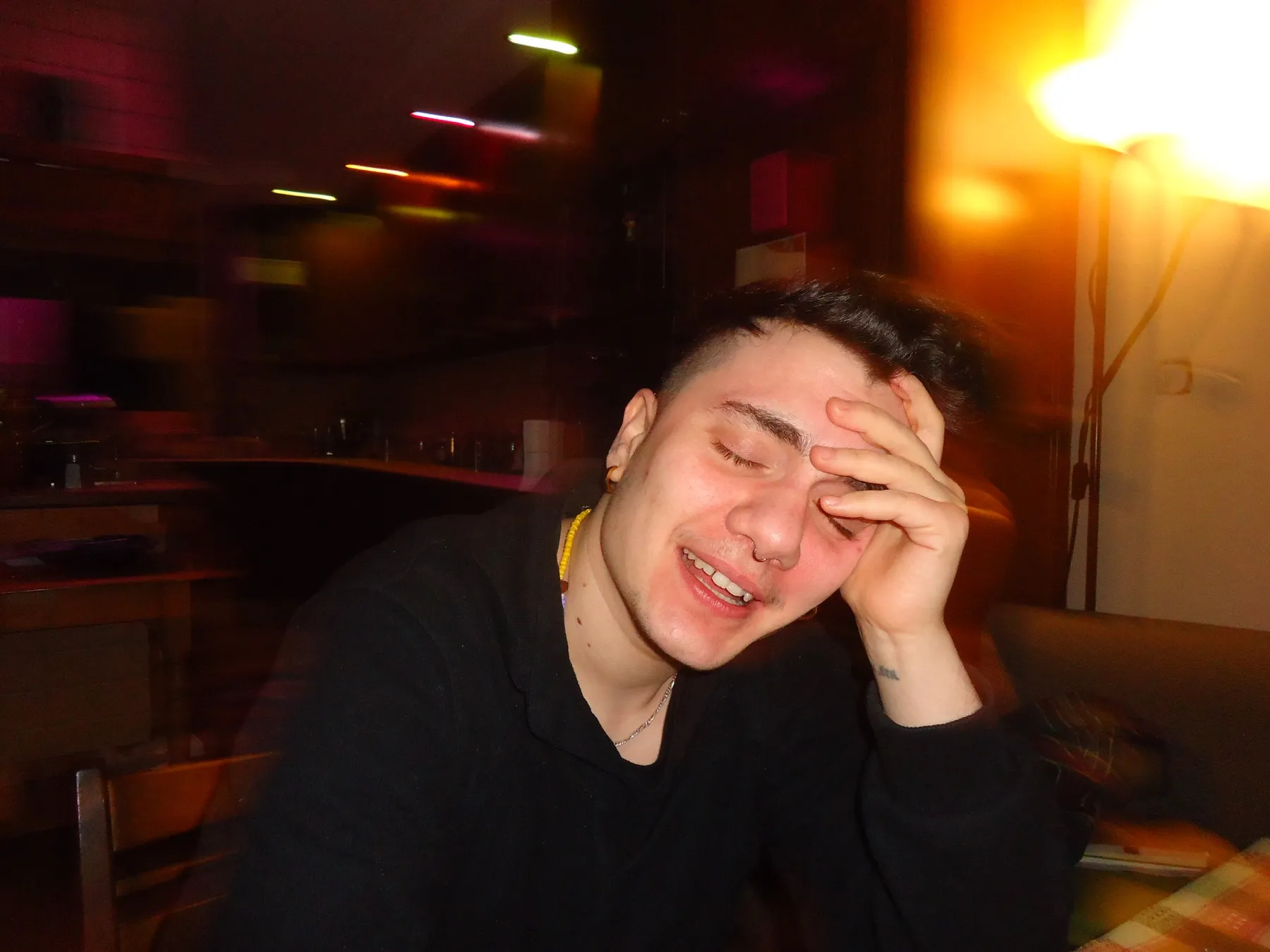 Young man laughing with his hand on his forehead