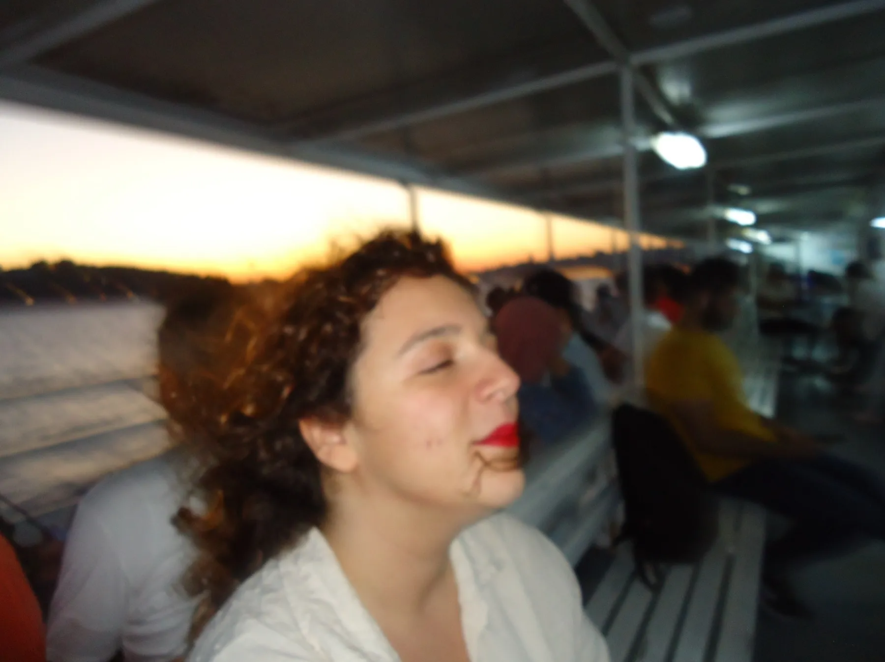 Woman with red lipstick on a ferry at sunset