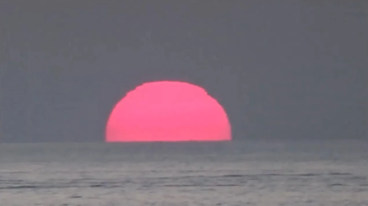 Pink sun setting over the sea