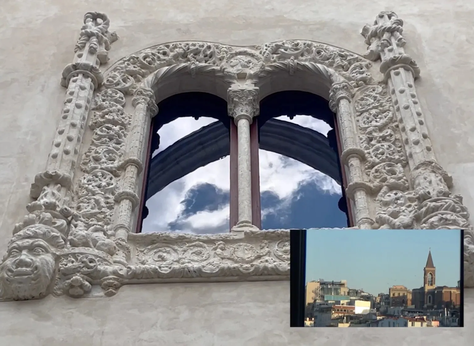 Carved stone window with a smaller city view set into the frame