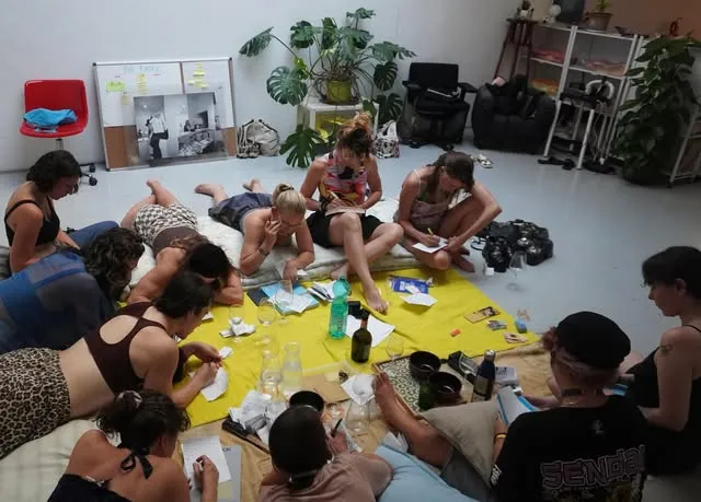 Participants of the Unveil Meeting in Rome writing and talking on the floor of a studio