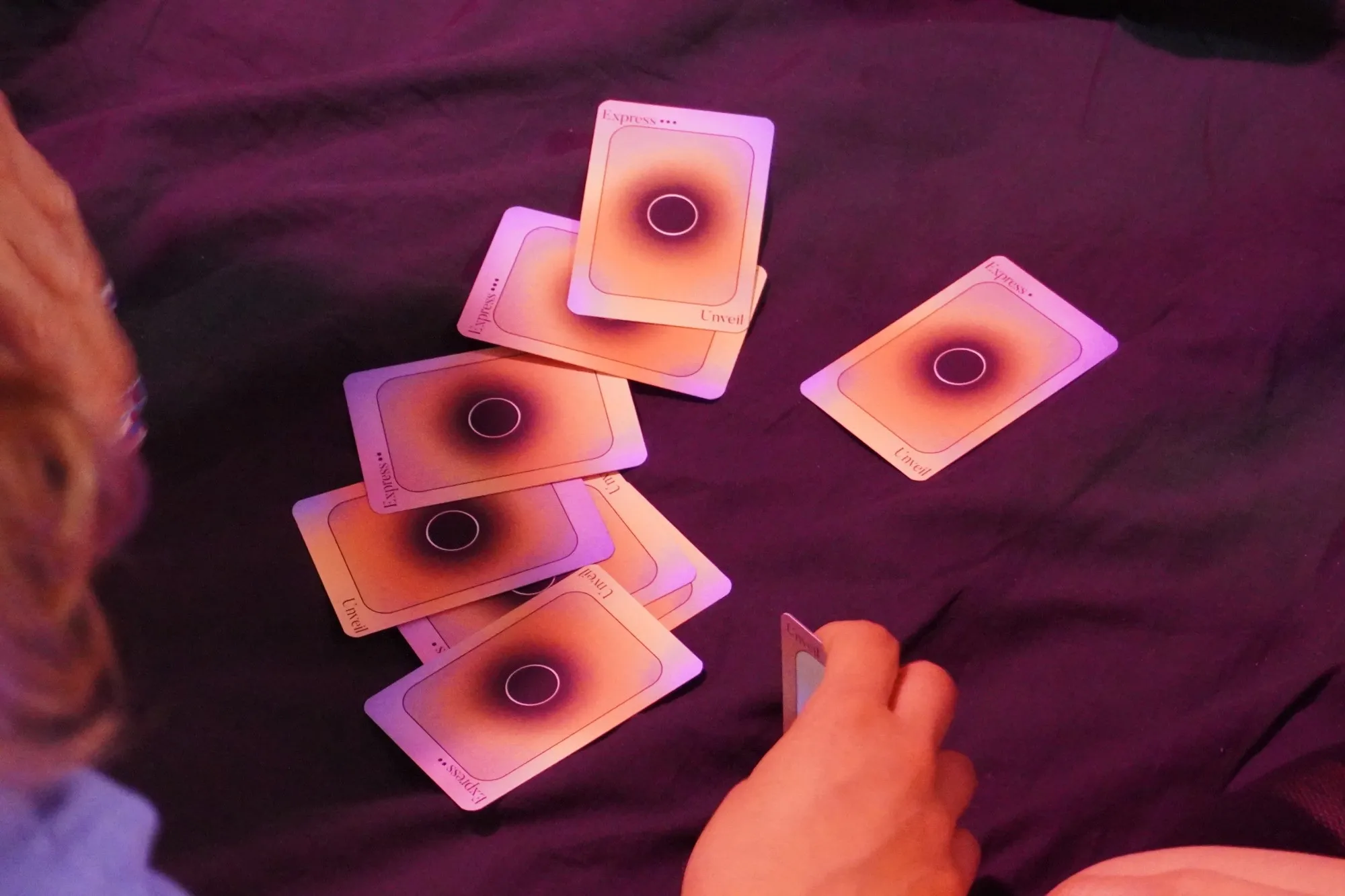 Express cards scattered on a dark cloth in pink light
