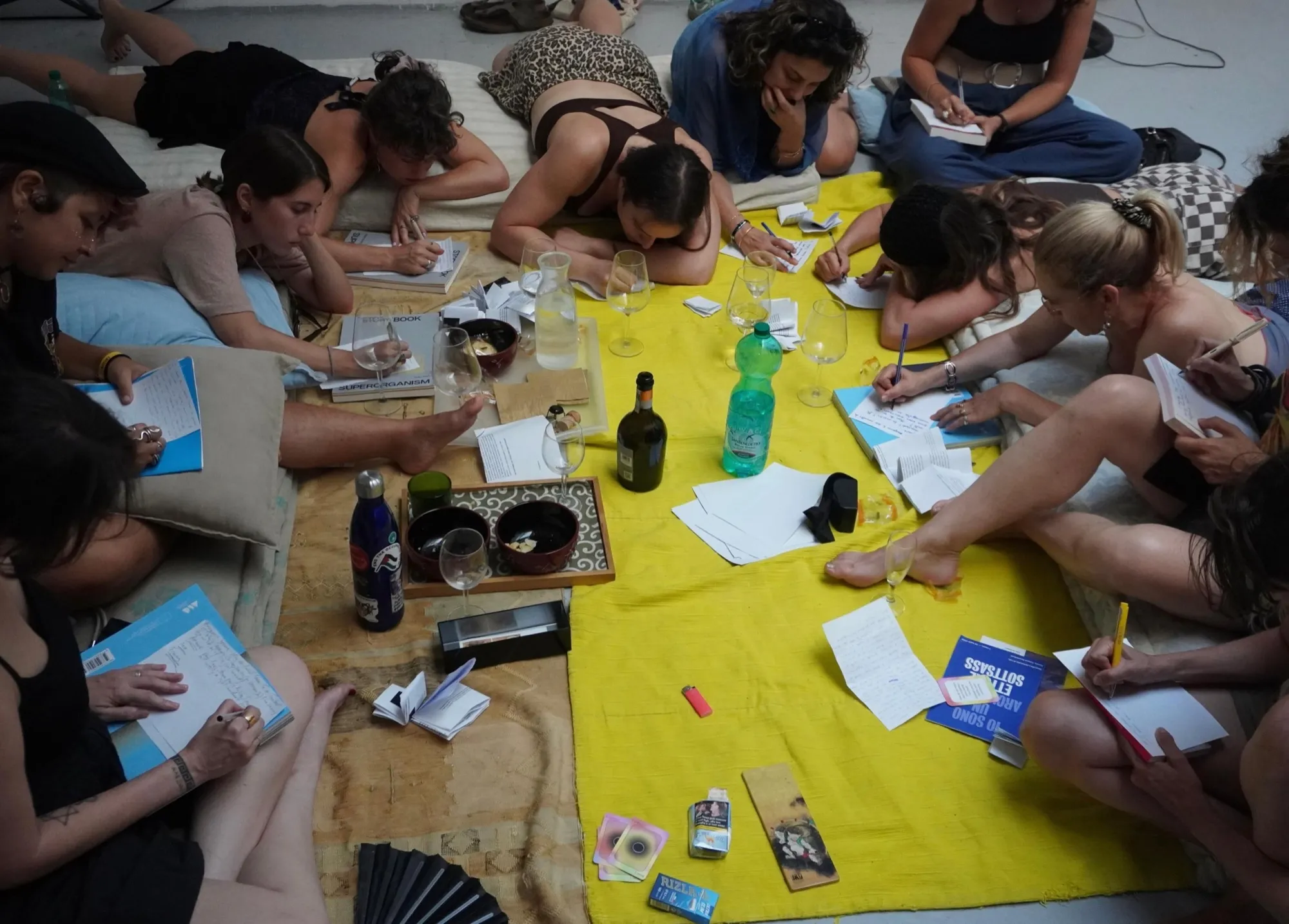 Participants of the first Unveil Meeting in Rome writing on the floor around a yellow cloth, with Unveil cards